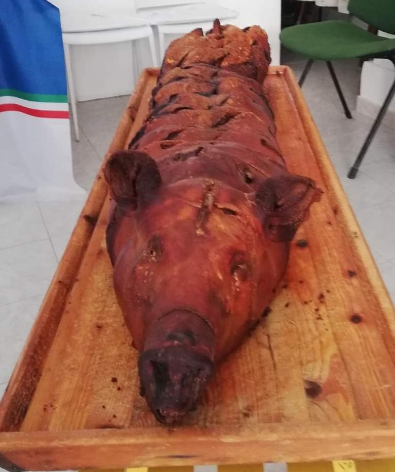 Porchetta Bucci disposta su tavola di legno durante una presentazione pubblica, Ripa Teatina, epoca contemporanea.